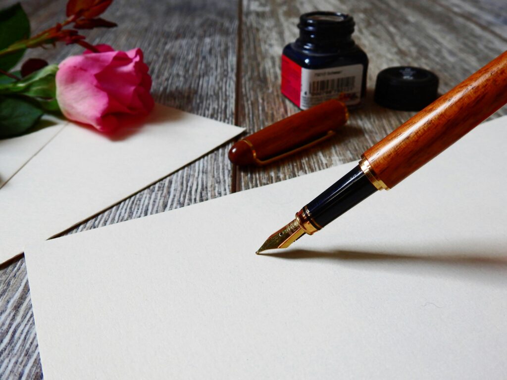 pexels-photo-356372-356372 A romantic setup with a rose, fountain pen, and paper, perfect for heartfelt writing.